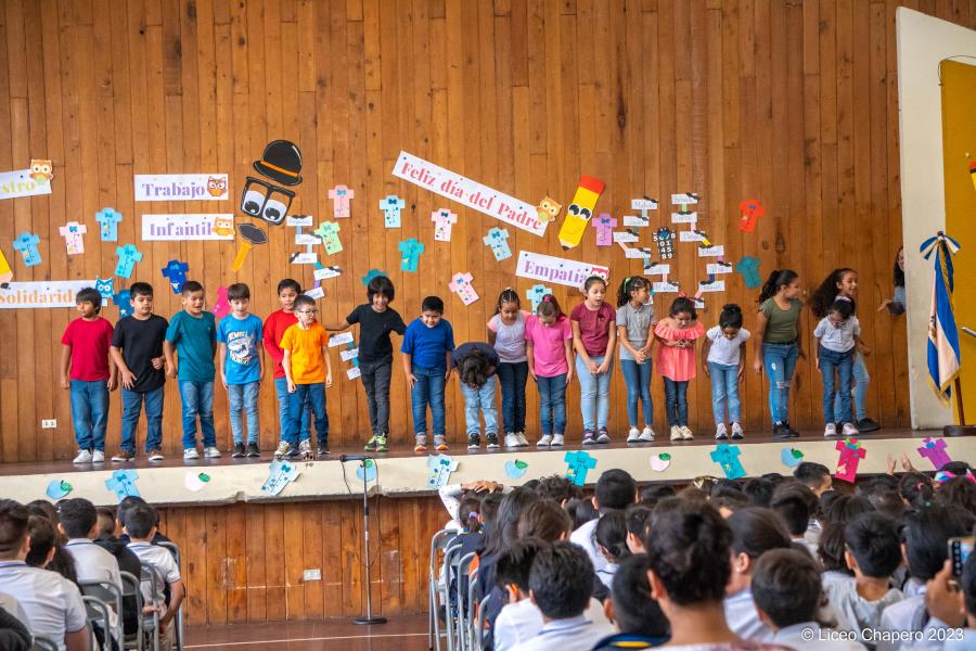 Estudiantes participan en una presentación sobre un escenario.